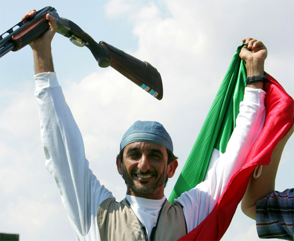 Sheikh Ahmad Al-maktoum of United Arab Emirates celebrates as he hold aloft his national flag after he won the men's double trap final of the Athens 2004 Olympic Games