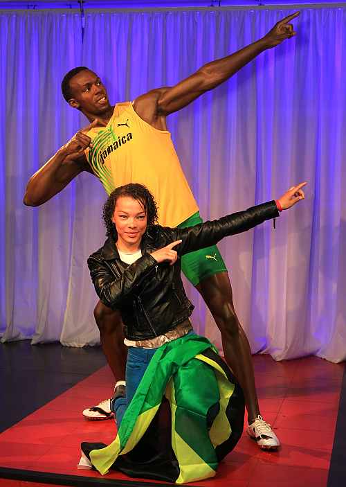 A visitor poses alongside the new Usain Bolt wax figure as it is unveiled at Madame Tussauds