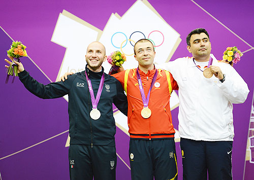 Gold medallist Alin George Moldoveanu (centre) of Romania, silver medallist Niccolo Campriani of Italy (left) and bronze medallist Gagan Narang of India pose on the podium