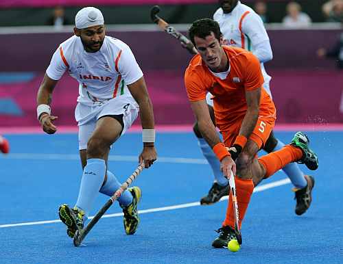 The Netherlands' Marcel Balkestein and India's Sandeep Singh vie for the ball during their men's hockey preliminary round match