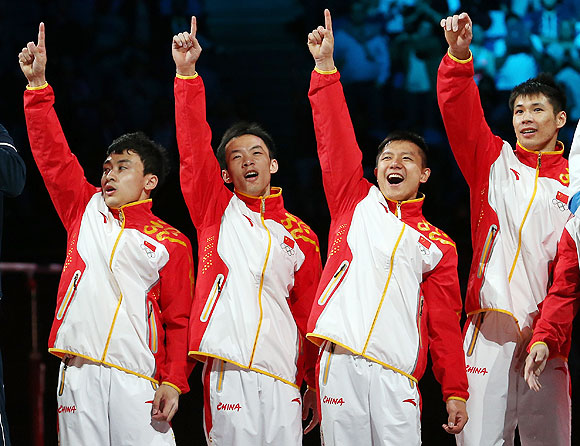 Gold medalists Zhe Feng, Weiyang Guo, Yibing Chen, Chenglong Zhang and Kai Zou of China celebrate on the podium during the medal ceremony in the Artistic Gymnastics Men's Team final on Monday