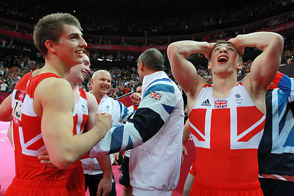 Max Whitlock and Sam Oldham of Great Britain react after hearing the scores on the final rotation in the Artistic Gymnastics Men's Team final on Monday