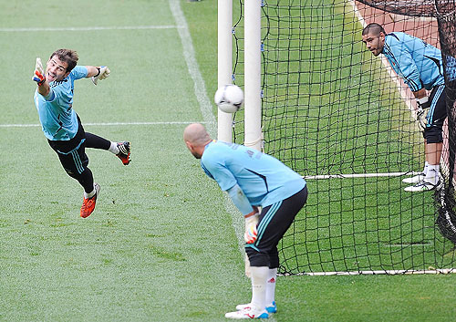 Iker Casillas (left) tries to save a shot while Pepe Reina (centre) and Victor Valdes look on during a training session
