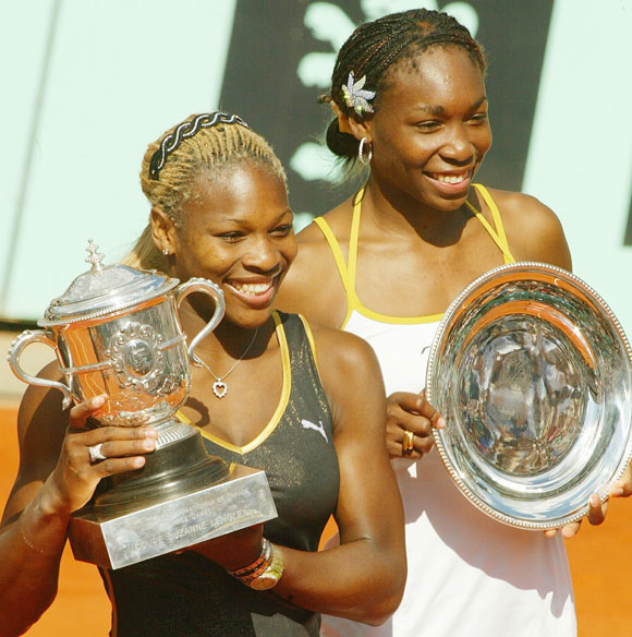 Serena Williams (left) and sister Venus pose with their trophies after the 2002 French Open final