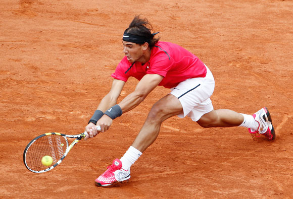 Rafael Nadal of Spain returns the ball to his compatriot Nicolas Almagro during their quarter-final match at the French Open