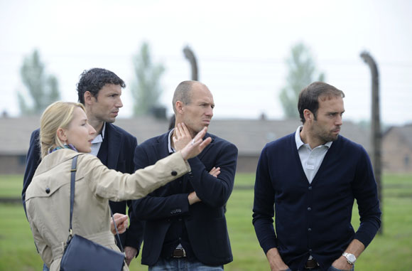 Netherlands' players Mark van Bommel, Arjen Robben and Joris Mathijsen (2nd L-R) listen to a guide during their visit to the Auschwitz-Birkenau former Nazi concentration camp