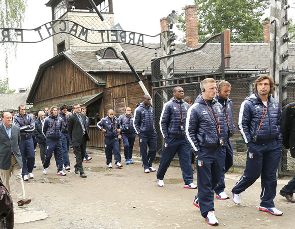 Italy's national soccer players walk through Auschwitz's notorious gate