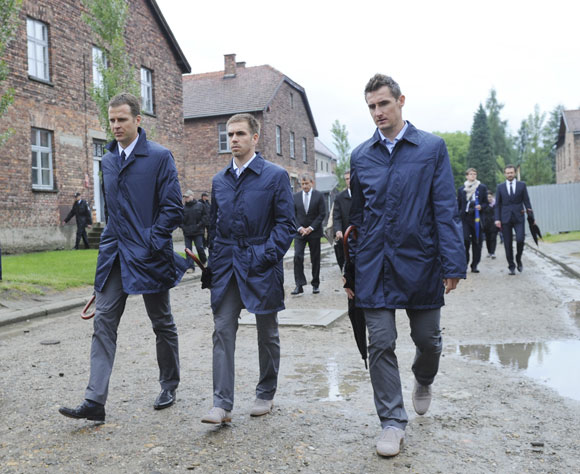 Germany team manager Oliver Bierhoff, captain Philipp Lahm and forward Miroslav Klose (L-R) walk through Auschwitz former concentration camp