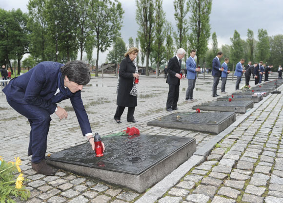 Germany's national soccer coach Joachim Lowe (L) places a candle to commemorate the victims of Auschwitz