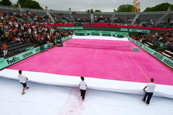 Groundstaff unveil a pink clay court prior to the women's legends doubles semi-final