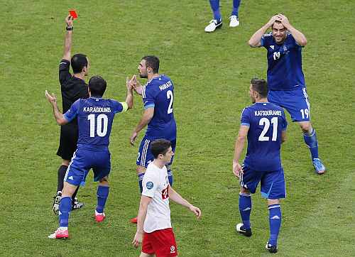 Greece's players react on a red card for Sokratis Papastathopoulos (R) during the Group A Euro 2012 soccer match against Poland at the National Stadium