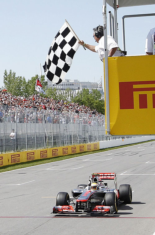 McLaren'sLewis Hamilton takes the chequered flag to win the Canadian GP
