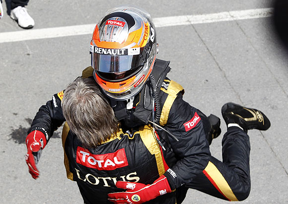 Lotus F1 driver Romain Grosjean of France hugs a crew member after the Canadian GP
