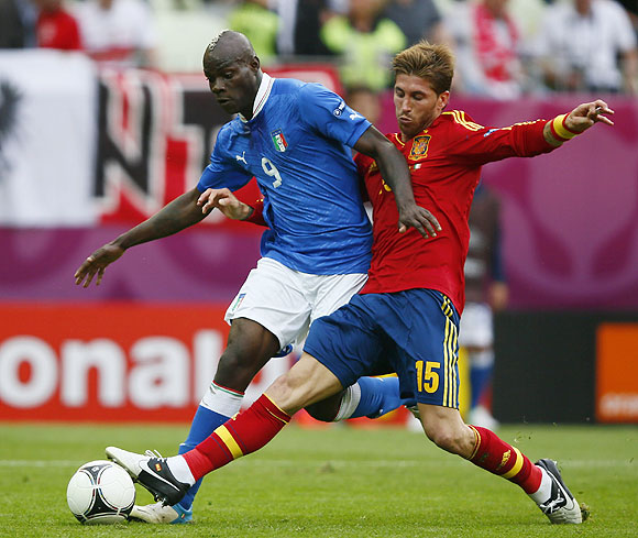 Italy's Mario Balotelli is challenged by Spain's Sergio Ramos (right)