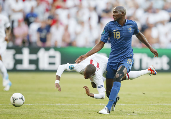 England's Ashley Young collides with France's Alou Diarra (R) during the Euro 2012 Group D soccer match at Donbass Arena in Donetsk