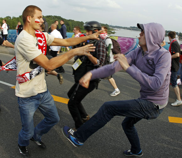 A Russian soccer fan fights with a Polish supporter (L) in Warsaw