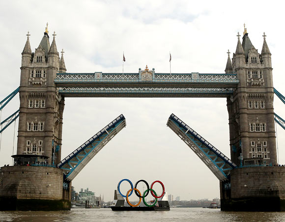 The Tower Bridge opens as the Olympic rings pass through on The River Thames in London