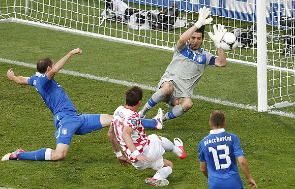 Croatia's Mario Mandzukic (centre) beats 'keeper Gigi Buffon to score against Italy