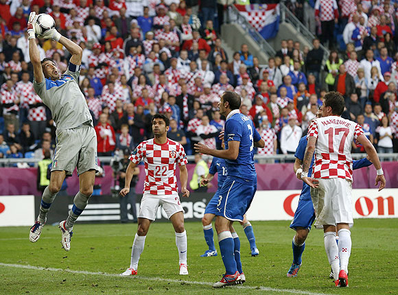 Italy's goalkeeper Gianluigi Buffon (left) makes a save as Croatia's Eduardo (centre) and Mario Mandzukic look on