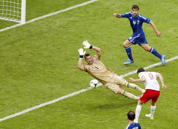 Poland's Robert Lewandowski (No.9) scores the first goal of the tournament past Greece goalkeeper Kostas Chalkias
