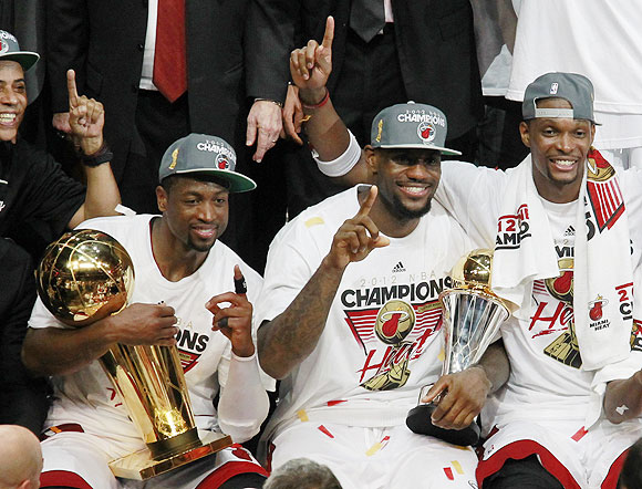 (From left) Miami Heat's Dwyane Wade, LeBron James and Chris Bosh celebrate with the trophy