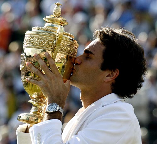 Roger Federer kisses the Wimbledon trophy