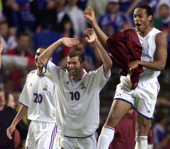 France's Zinedine Zidane (10) celebrates with Thierry Henry (R) and David Trezeguet after winning the match against Portugal