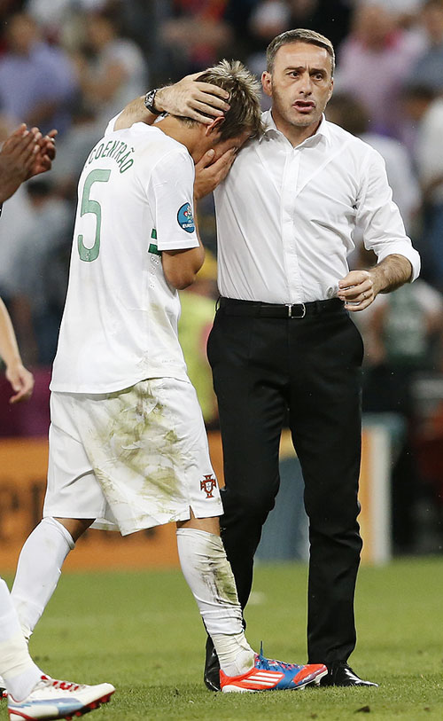 Portugal's Fabio Coentrao (left) is comforted by coach Paulo Bento after losing to Spain