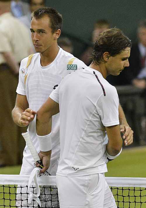 Lukas Rosol leaves after shaking hands with Rafael Nadal after defeating him in their men's singles match at the Wimbledon