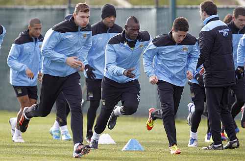 Manchester City players warm up during a practice session