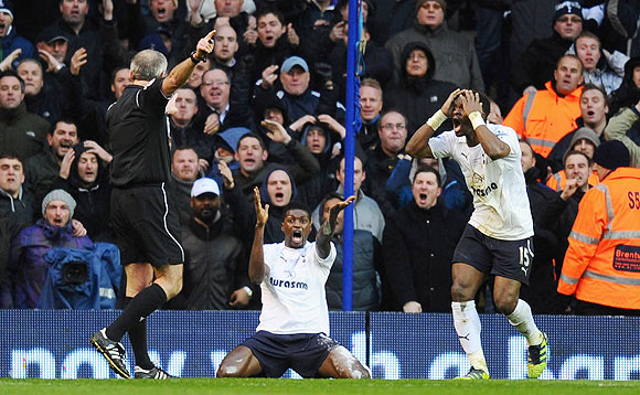 Emmanuel Adebayor (centre) and Louis Saha of Tottenham Hotspur react after referee Martin Atkinson (left) disallowed a goal