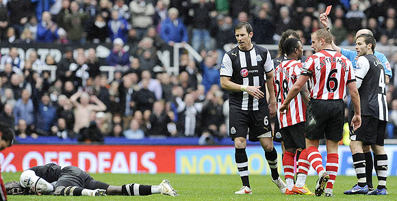 Referee Mike Dean (right) sends off Sunderland's Stephane Sessegnon (3rd from right) for a challenge on Cheick Tiote (left) during their match on Sunday