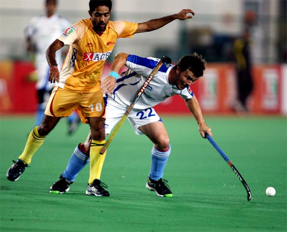 Karnataka's Ravipal Singh loses his stick as he goes for a tackle
