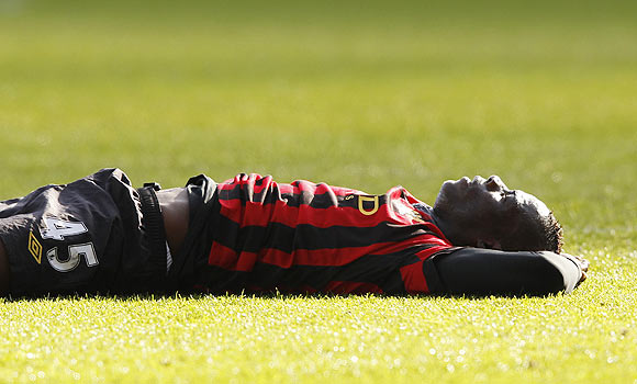 Mario Balotelli of Manchester City lies on the ground after missing a chance on goal against Swansea City on Sunday