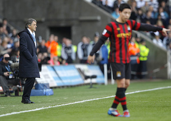 Manchester City manager Roberto Mancini looks on with Sami Nasri in the foreground