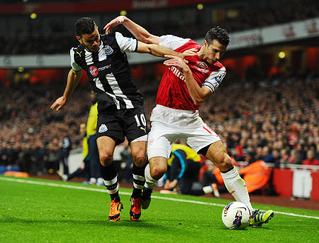 Hatem Ben Arfa of Newcastle and Robin van Persie of Arsenal battle for the ball
