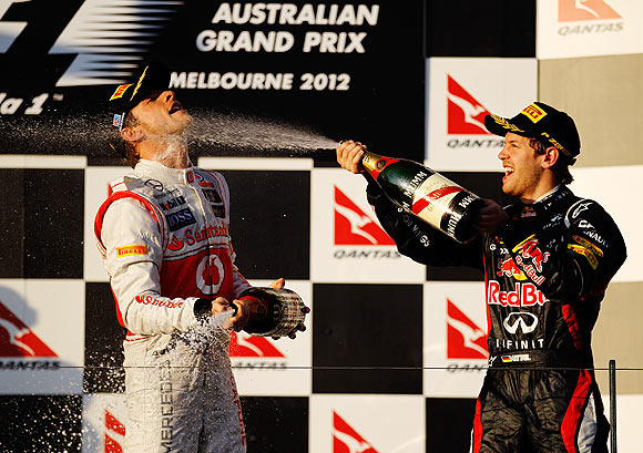 Jenson Button (left) celebrates with second placed Sebastian Vettel on the podium after the Australian GP on Sunday