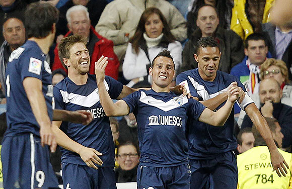 Malaga's Santiago Cazorla (2nd from right) celebrates with teammates after netting against Real Madrid during their La Liga match on Sunday