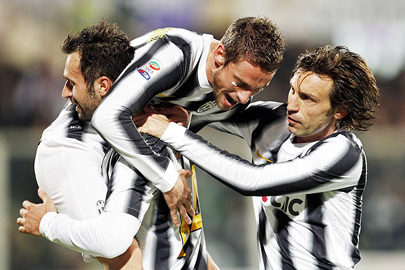Juventus' Claudio Marchisio (centre) celebrates with teammates Mirko Vucinic (left) and Andrea Pirlo after scoring against Fiorentina during their Serie A match on Saturday