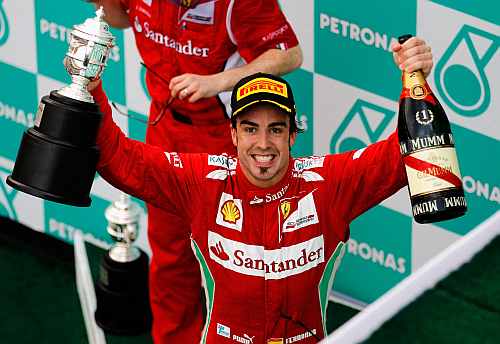 Ferrari's Fernando Alonso celebrates on the podium after winning the Malaysian Formula One Grand Prix at the Sepang Circuit