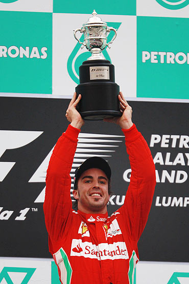 Fernando Alonso celebrates on the podium after winning the Malaysian Formula One Grand Prix on Sunday