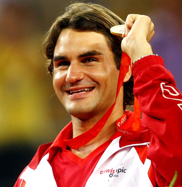 Roger Federer celebrates with his gold medal won with partner Stanislas Wawrinka in the men's doubles tennis event at the 2008 Beijing Olympics