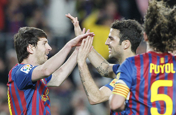 Barcelona's Lionel Messi celebrates with Cesc Fabregas (right) after scoring against Malaga on Wednesday