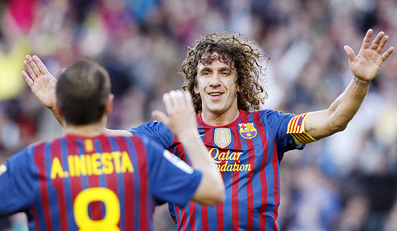 Barcelona's Carles Puyol (right) celebrates with Andres Iniesta after scoring the opener against Malaga on Wednesday