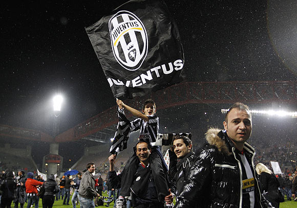 Juventus' fans celebrate after the team won the Serie A title following their match against Cagliari at the Nereo Rocco stadium in Trieste on Sunday