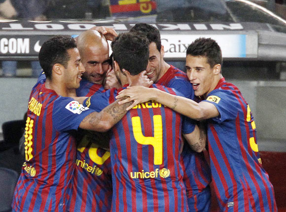 Barcelona's players celebrate with coach Pep Guardiola after Messi scored the fourth goal against Espanyol on Saturday