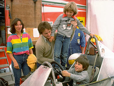 Gilles Villeneuve puts son Jacques at the controls of his Ferrari Formula One racing car whilst being pictured with his family in the Ferrari paddock during the 1979 formula one racing season