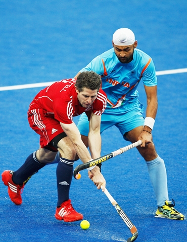 Great Britain's Simon Mantell battles for the ball with Sandeep Singh atthe Olympic test event in London