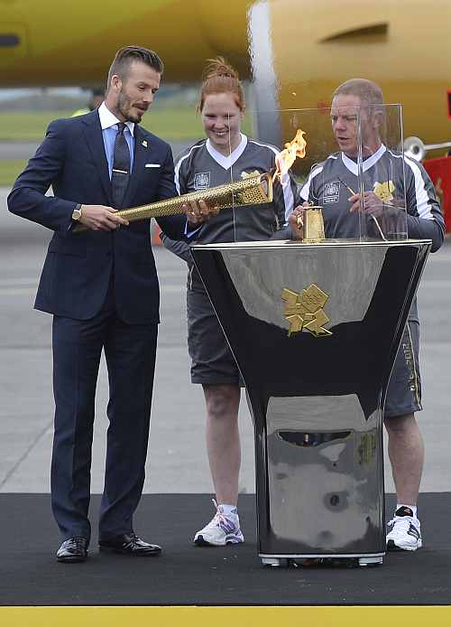 British soccer player and London 2012 Olympic Games ambassador David Beckham reacts after lighting the Olympic torch with a cauldron