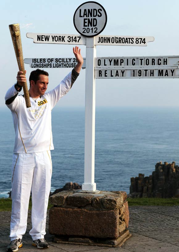 Olympic gold medal sailor and the first London 2012 torchbearer, Ben Ainslee, poses for a photograph beside the Lands End sign.